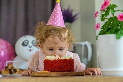 Child is two years old with a cake and candles. Selective focus. Kid.