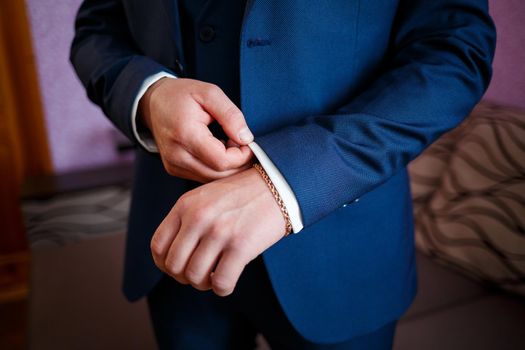 man puts on a suit on the wedding day