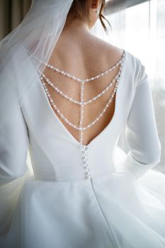Bride zips zipper on her wedding white dress