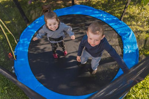 top view of small children jumping on a trampoline