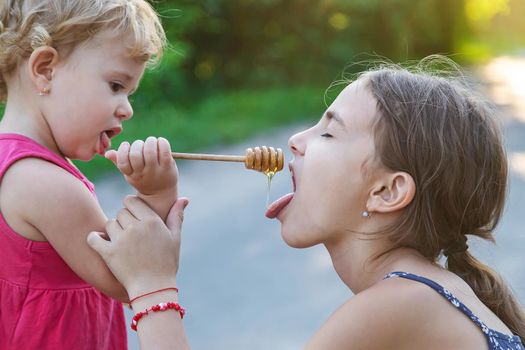 A child eats honey in the park. Selective focus. Kid.