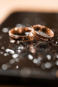 Gold wedding rings for newlyweds on their wedding day. Jewelry for the holiday of a couple in love. Selective focus