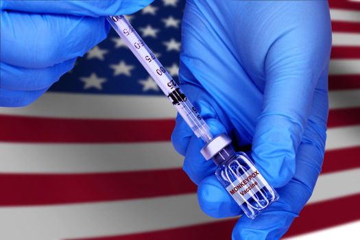 Monkeypox vaccine close-up on blurred background of united states of america flag.