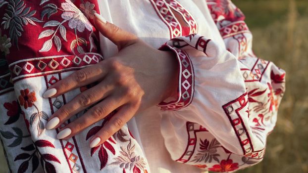 Ukrainian woman demonstrating beautiful details of embroidery ornament on vyshyvanka shirt. National costume - embroidered shirt, texture, design, folk, handmade craft needlework. High quality photo