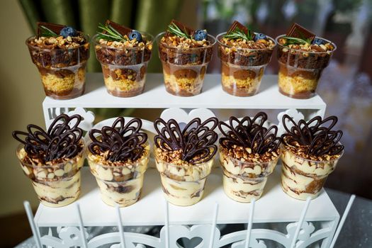 Beautifully decorated sweet buffet table on which cakes, muffins, marshmallows, pecans. Dessert table for a party, goodies for the wedding. Close up. Candy bar. A buffet for a wedding