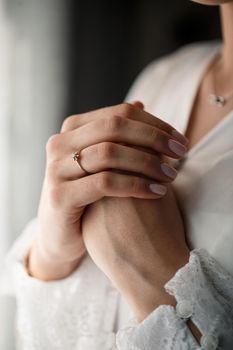 Gentle female hands of the bride with a gold wedding ring on the ring finger