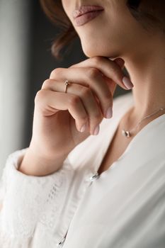 Gentle female hands of the bride with a gold wedding ring on the ring finger