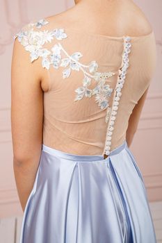The back of a girl in a dress with buttons