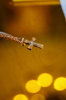 Golden cross lies on a wooden table