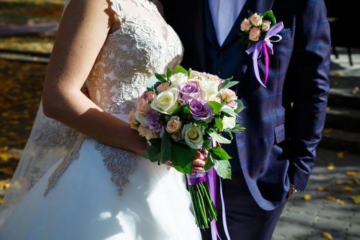 Beautiful wedding bouquet of flowers in the hands of the newlyweds