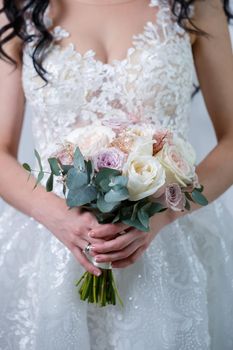 Beautiful wedding bouquet of flowers in the hands of the newlyweds