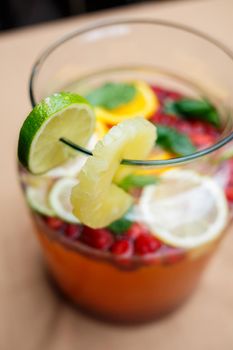 Refreshing lemonade with fresh fruit orange lemon cherry and mint leaves. Delicious non-alcoholic fruit cocktail in a jug