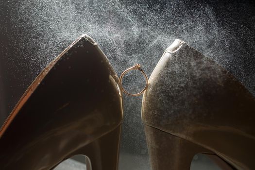 Gold wedding ring with women's shoes on the wedding day