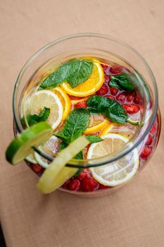 Refreshing lemonade with fresh fruit orange lemon cherry and mint leaves. Delicious non-alcoholic fruit cocktail in a jug