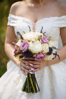 Beautiful wedding bouquet of flowers in the hands of the newlyweds