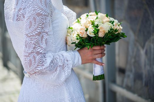 A bouquet of fresh flowers in the hands of the bride