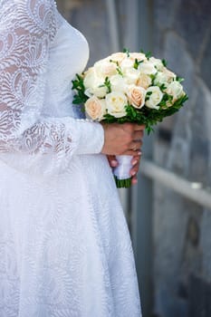 A bouquet of fresh flowers in the hands of the bride
