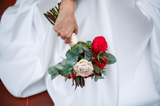 Beautiful wedding bouquet of flowers in the hands of the newlyweds