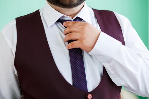 man puts on a suit on the wedding day