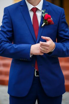 man puts on a suit on the wedding day