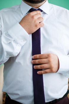 man puts on a suit on the wedding day