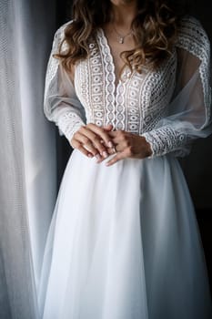 Gentle female hands of the bride with a gold wedding ring on the ring finger