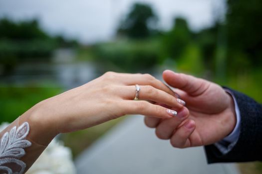 Gentle female hands of the bride with a gold wedding ring on the ring finger