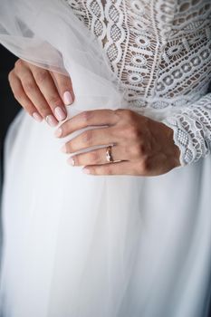 Gentle female hands of the bride with a gold wedding ring on the ring finger