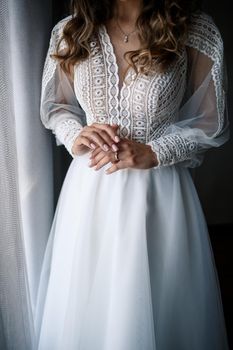 Gentle female hands of the bride with a gold wedding ring on the ring finger