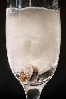 Gold precious wedding rings in a glass of sparkling champagne