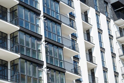 Large panoramic plastic windows. Facade of a new building in the house during construction work. Multi-storey building during construction
