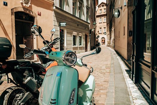 Prague, Czech Republic - July 2022. Retro Italian Vespa scooter in blue turquoise color on old european street. Motor bike, moped, transport mode, speed concept. High quality photo