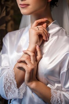 Gentle female hands of the bride with a gold wedding ring on the ring finger