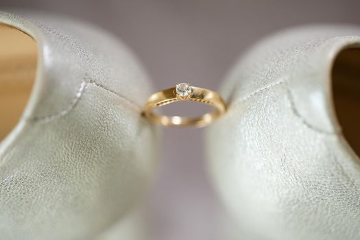 Gold wedding ring with women's shoes on the wedding day