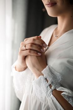 Gentle female hands of the bride with a gold wedding ring on the ring finger