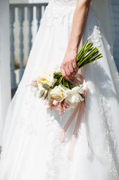 Beautiful wedding bouquet of flowers in the hands of the newlyweds