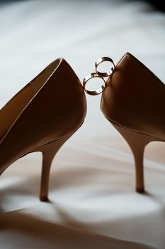 Gold wedding ring with women's shoes on the wedding day