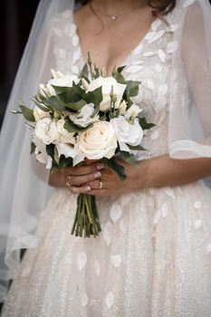 A bouquet of fresh flowers in the hands of the bride