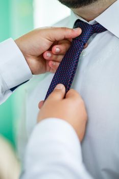 man puts on a suit on the wedding day