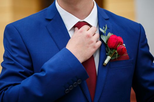 man puts on a suit on the wedding day