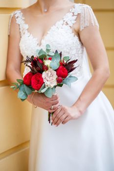 Beautiful wedding bouquet of flowers in the hands of the newlyweds