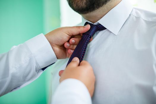 man puts on a suit on the wedding day