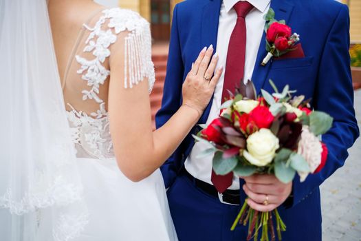 Beautiful wedding bouquet of flowers in the hands of the newlyweds