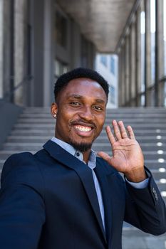 vertical view smartphone camera African American businessman speaks on phone using a front camera on a video call. Black business man talking on webcam. Conversation of an office worker in suit