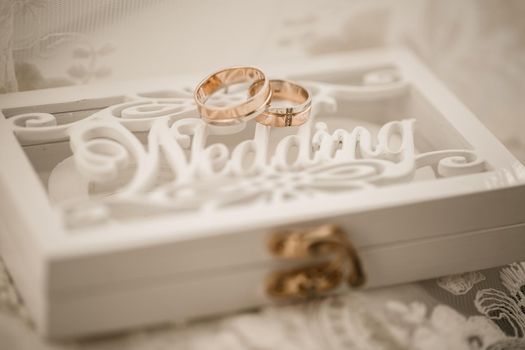 Gold wedding rings for newlyweds on their wedding day. Jewelry for the holiday of a couple in love