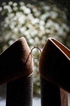 Bride's engagement ring on wedding day with beautiful holiday shoes