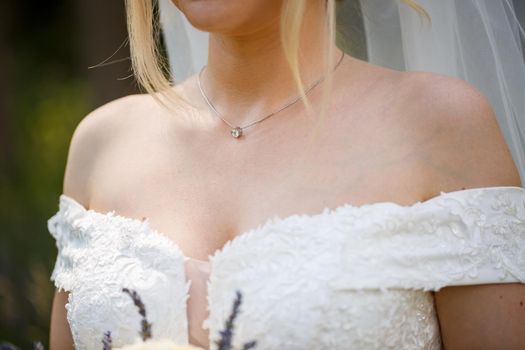 bride puts on wedding jewelry on the wedding day