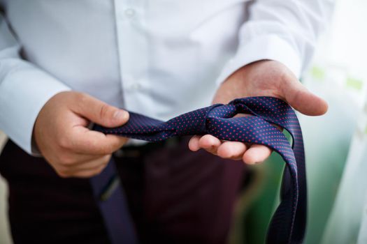 man puts on a suit on the wedding day
