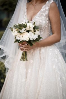 A bouquet of fresh flowers in the hands of the bride