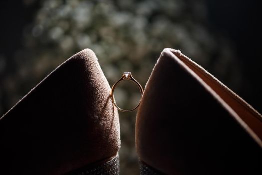 Bride's engagement ring on wedding day with beautiful holiday shoes